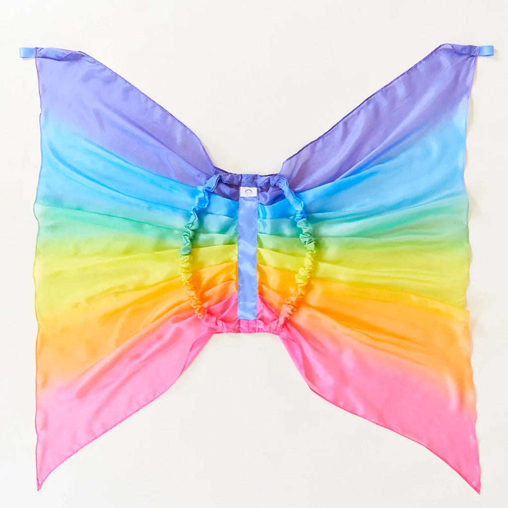 Sarah's Silks Rainbow Fairy Wings Children's Dress-Up Accessory. Ombre rainbow silk dress-up fairy wings for children. Each wing has a small silk loop at the top for children to grab. Elastic loops attached to back of wings for wear. Image shows the loops for reference. 
