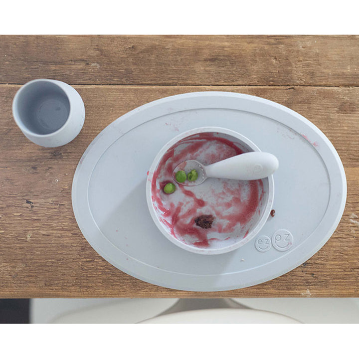 Toddler practicing independent drinking with the Pewter EZPZ Silicone Tiny Cup for Infants & Toddlers, soft ezpz cup support