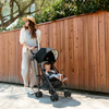 Mom pushing baby in UPPAbaby G-Lite Stroller in black