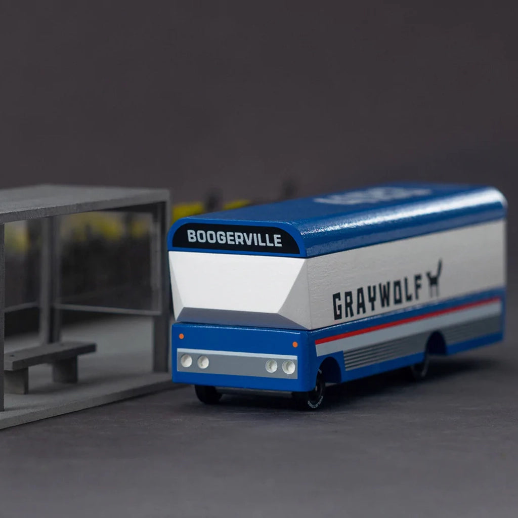 Lifestyle image of the Candylab Graywolf bus wooden toy on a play surface.