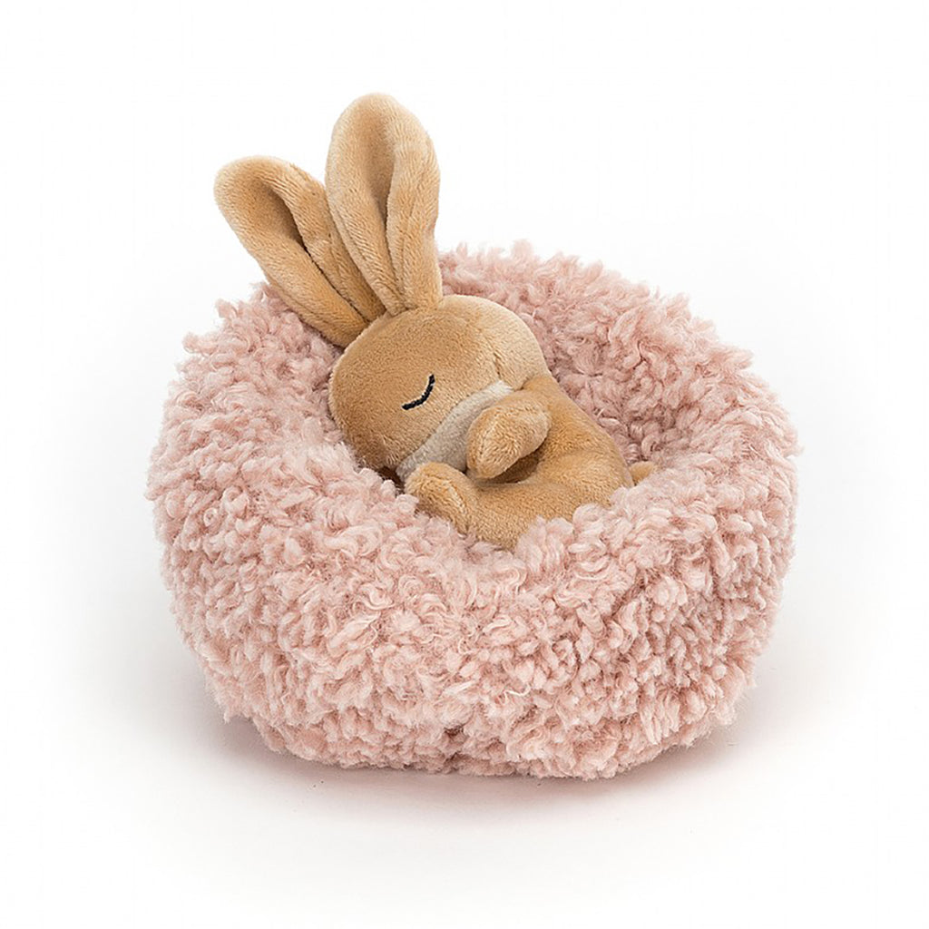 Jellycat Hibernating Bunny Stuffed Animal Children's Toy. Removable caramel colored rabbit plushie with a soft pink sherpa nest.
