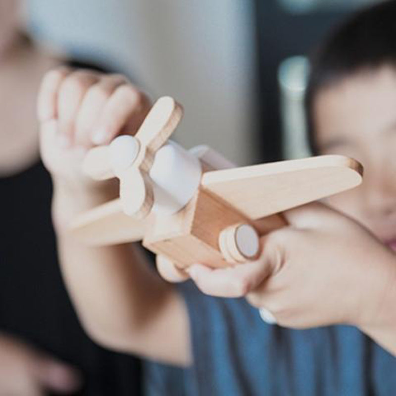 Wooden toy airplane with friction-powered propeller, crafted by Kiko+.