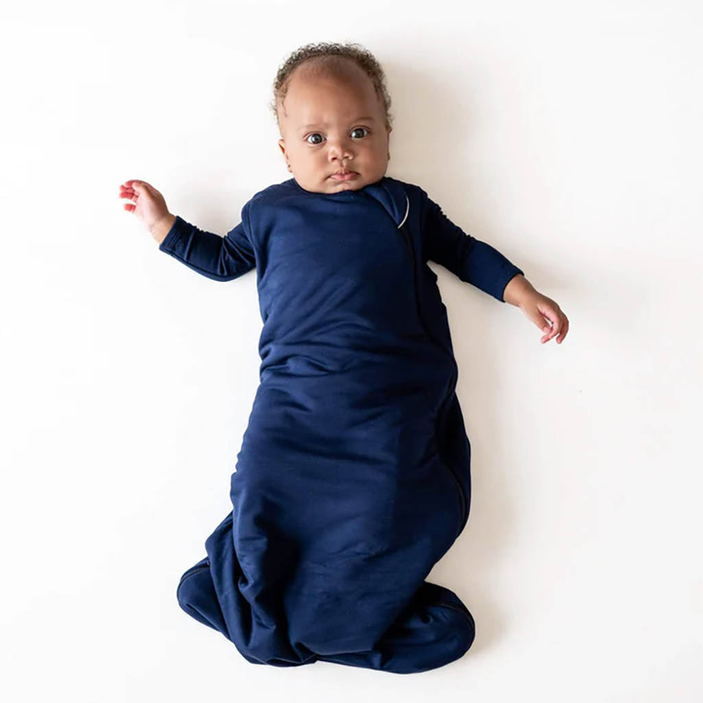 Baby wearing Kyte Baby Sleep Sack in Navy Blue