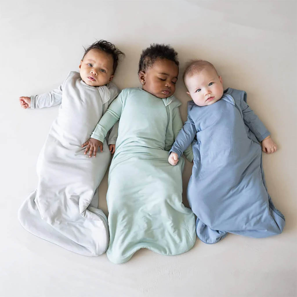 Three babies wearing Kyte Baby Sleep Sacks