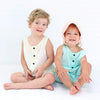 child sitting while wearing Kyte Baby Linen Girls Baby Bonnet 
