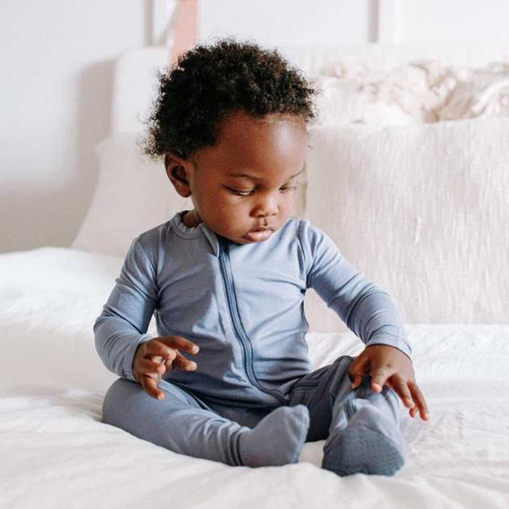 cute baby wearing Kyte footie pajamas in slate blue