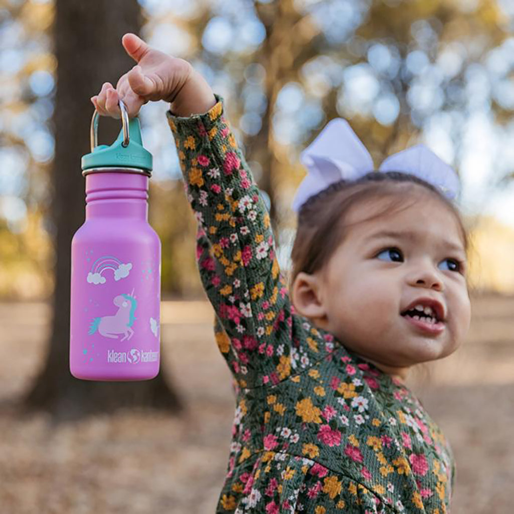 Klean Kanteen sippy bottle in pink held up by toddler