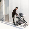 Mom walking with Uppababy Vista Stoller and Mesa Infant Car Seat