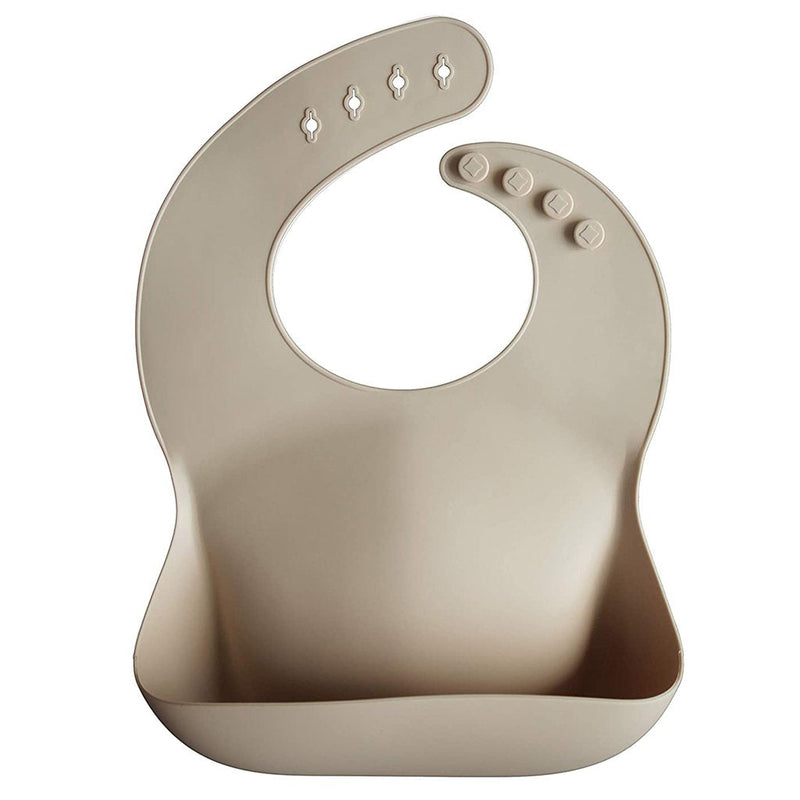 Mushie Shifting Sand Silicone Bib Durable silicone bib in Shifting Sand color to protect against food messes