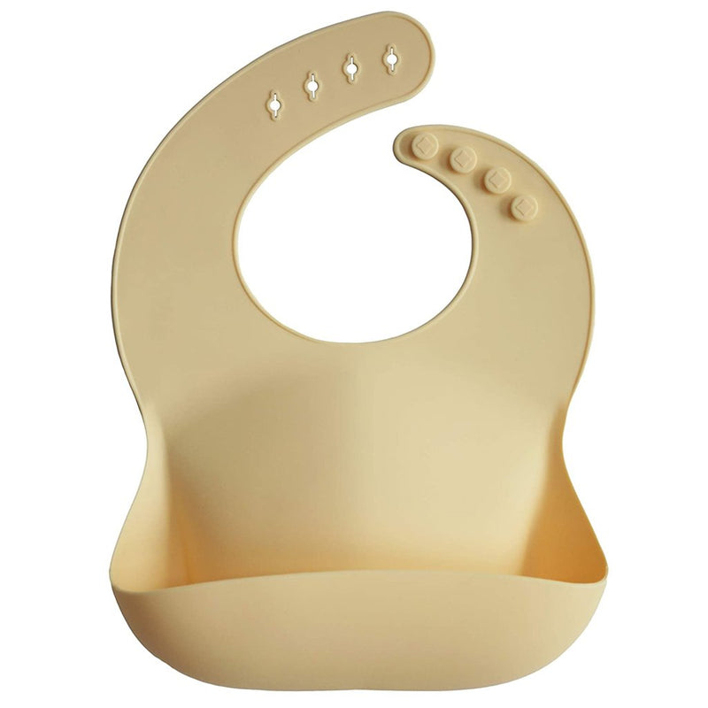 Mushie Sunshine Silicone Bib Adjustable Food-Grade Cover Muted Light Yellow Adjustable food-grade silicone bib in muted light yellow for babies