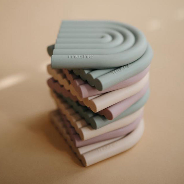 Assorted Mushie products including baby essentials like teethers and changing pads