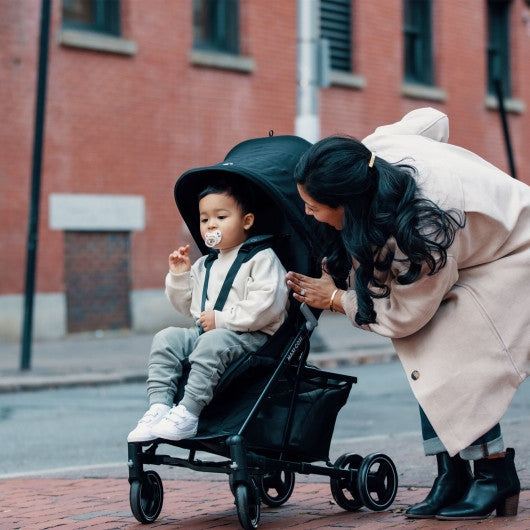 Maxi Cosi stroller in plum, showing a lifestyle image of the stroller in action with a baby comfortably seated.