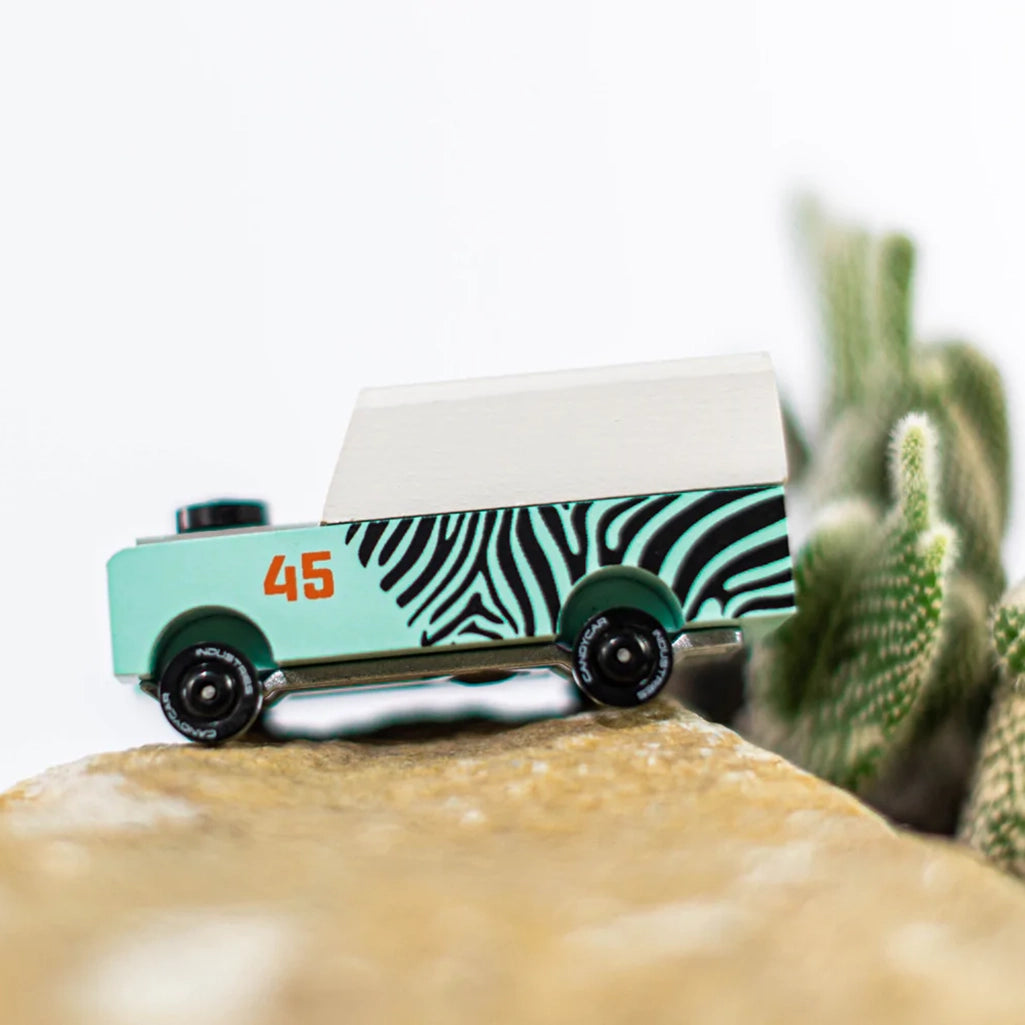 A lifestyle image of the Candylab Mini Zebra Drifter wooden toy vehicle, showcasing it in a fun play scenario.