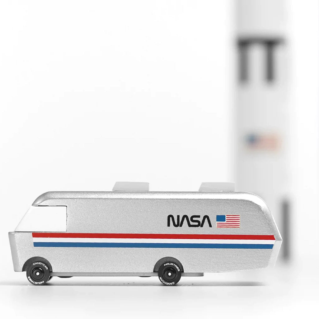 A lifestyle image of the Candylab NASA Astrovan wooden car, being used for pretend space exploration.