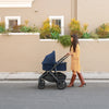 Woman Pushing Uppababy Cruz Stroller with Bassinet Accessory in Noa
