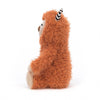 Jellycat Pip Monster Stuffed Animal Children's Toy. Burnt orange furry monster with tan face, hands, and feet. Two black and white striped horns on top of its head. Wide eyes and small brown nose with little stitched smile. Side view.