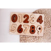 brown and beige wooden number puzzle on woven background. infant children's puzzle montessori toy