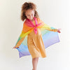 Lifestyle image of child modeling a rainbow Playsilk as a cape.
