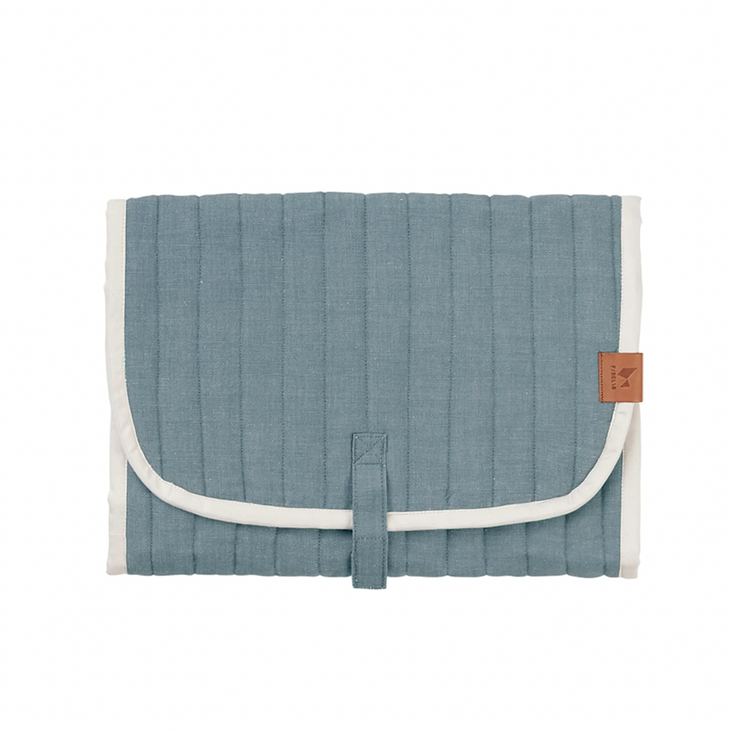 Fabelab Chambray Blue Spruce Infant Changing Mat. Chambray Blue quilted changing mat with white piping. Velcro strap to close. White quilted interior. 