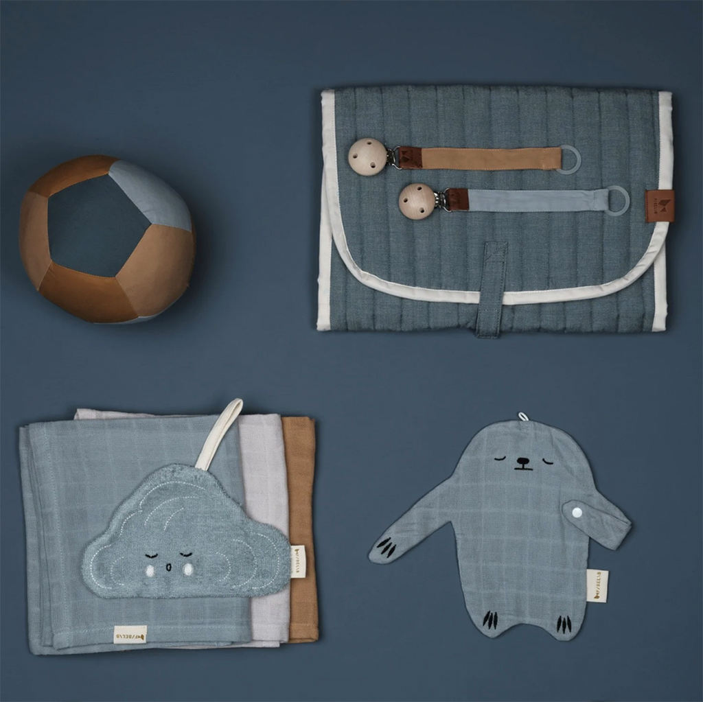 Flatlay image featuring Fabelab's Chambray Blue Spruce Changing Mat with other Fabelab products.