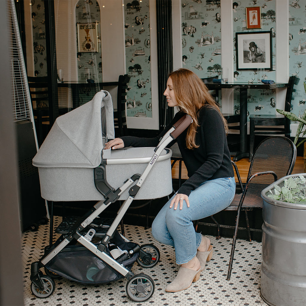 Woman at Restaurant Uppababy Cruz Stroller with Bassinet Accessory
