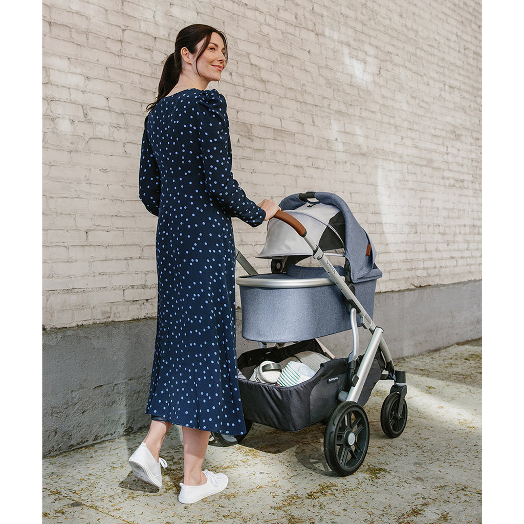 Woman walking with Uppababy Vista Stroller with bassinet accessory in Gregory