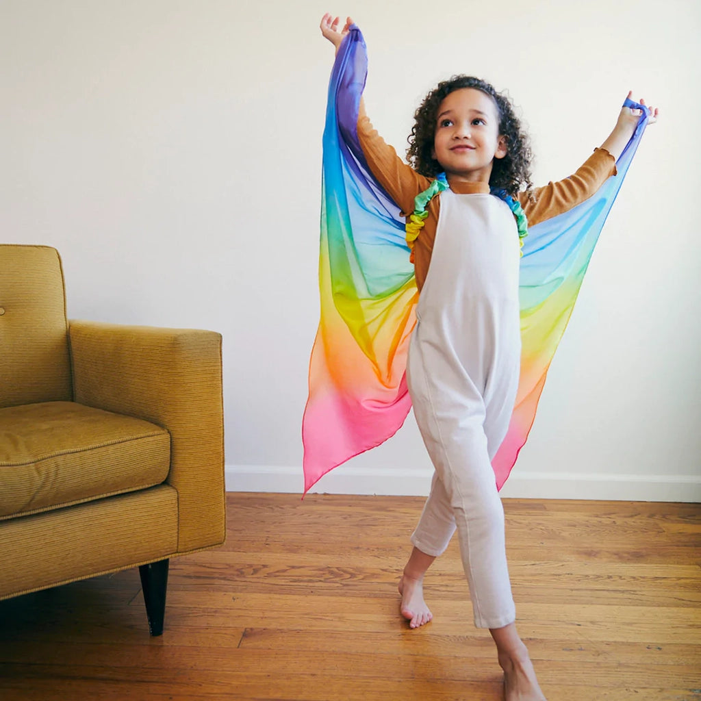 Sarah's Silks Rainbow Fairy Wings Children's Dress-Up Accessory. Modeled on child engaging in active play.