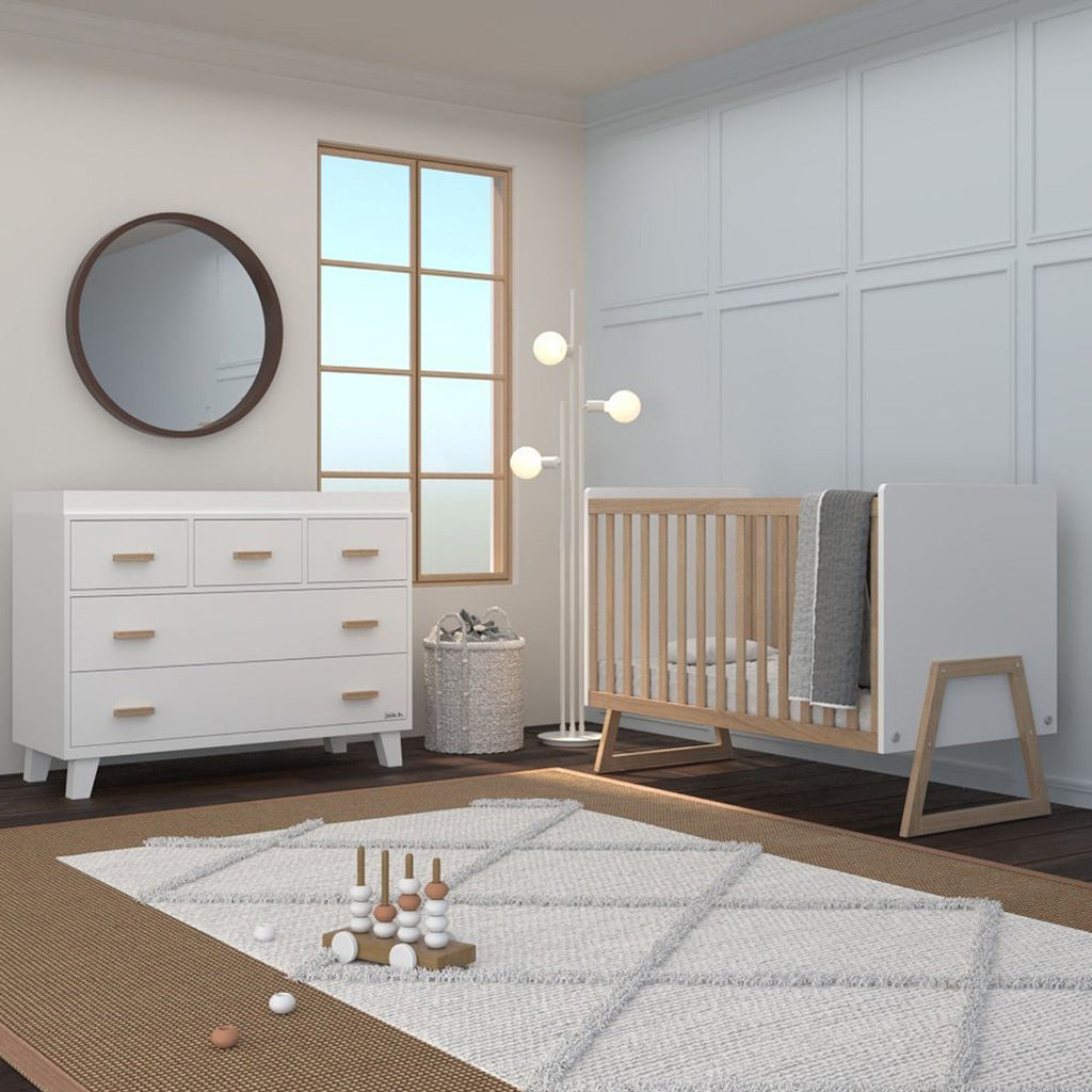 Lifestyle image of the Domino 2-in-1 Convertible Crib in White in a nursery.