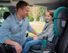 Parent smiling at child in Uppababy Teal Luca Alta booster seat in car