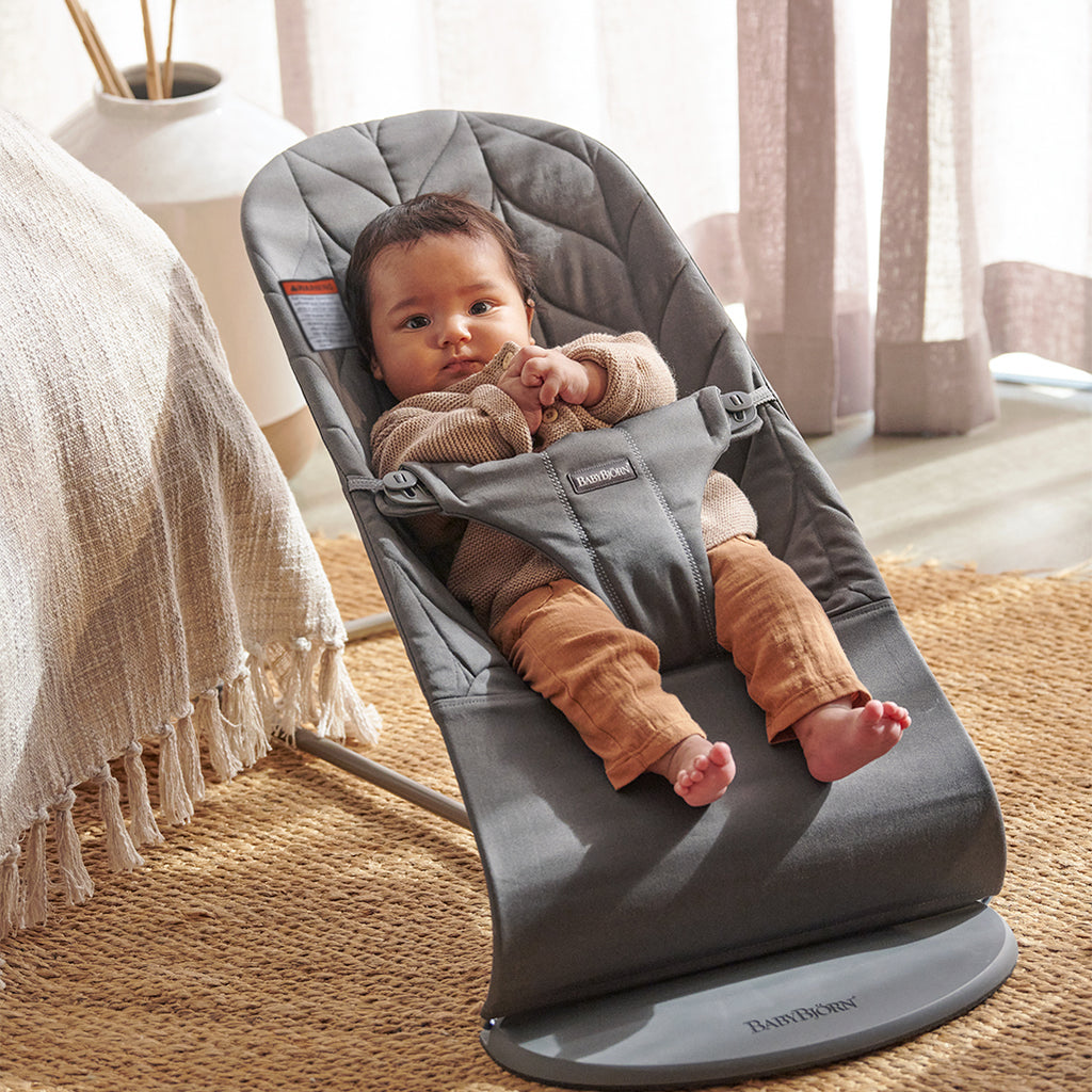 baby in bedroom with anthracite petal quilt babybjorn baby bouncer