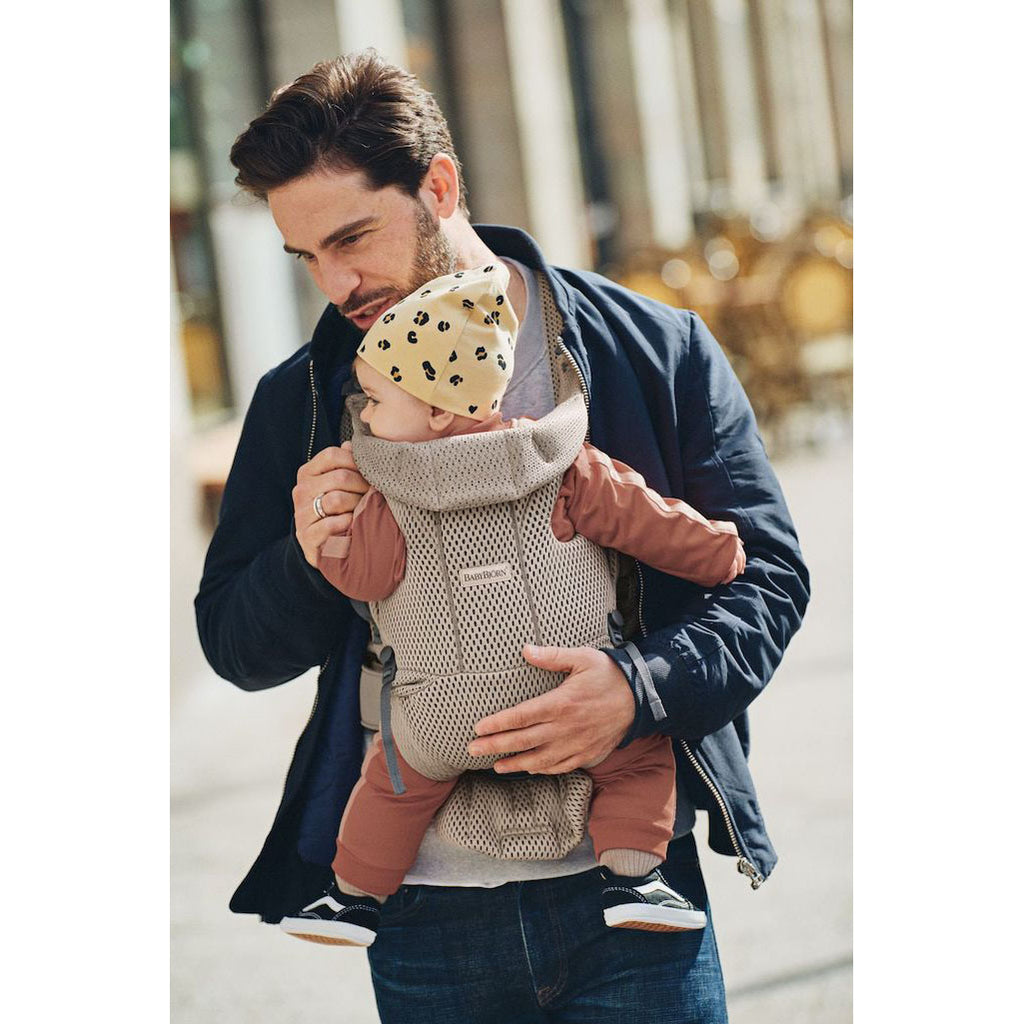 dad supporting infant in baby bjorn baby carrier grey free