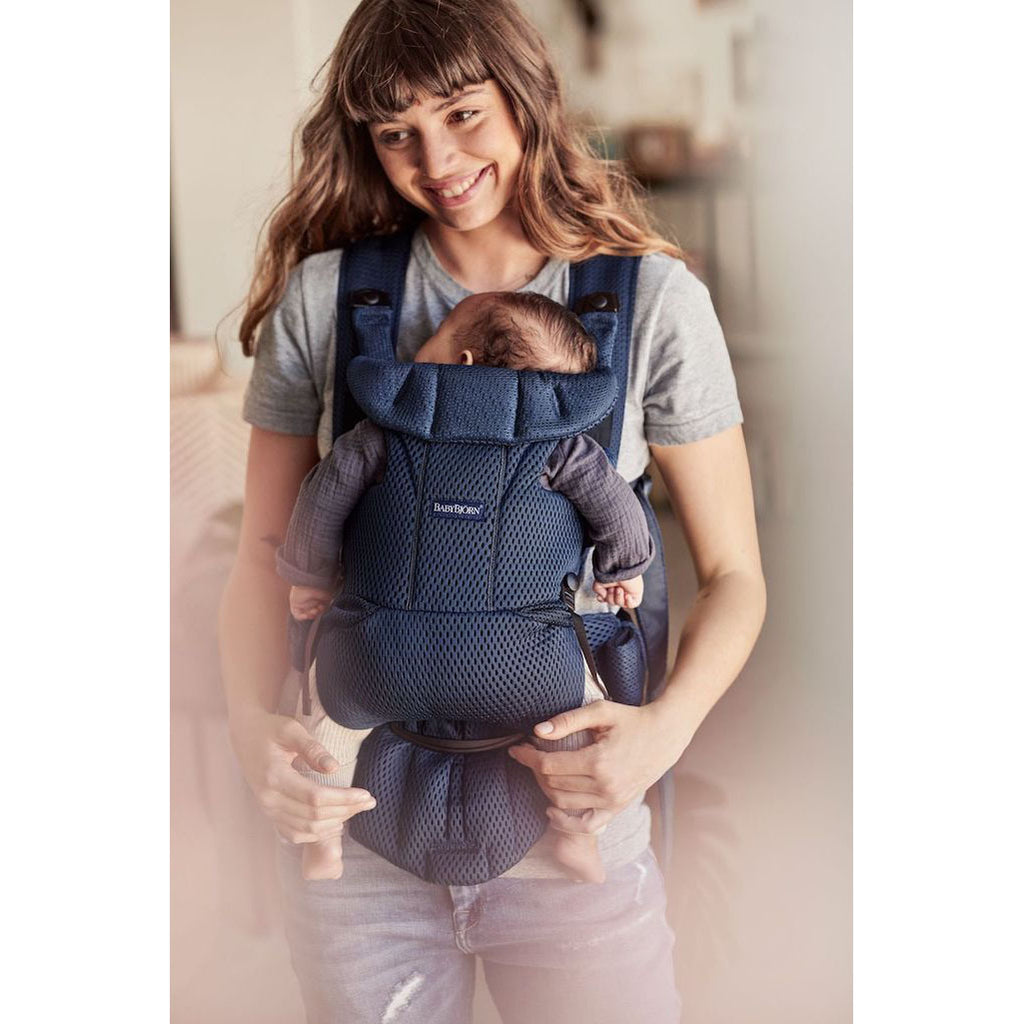 Mom holding baby in baby bjorn free carrier