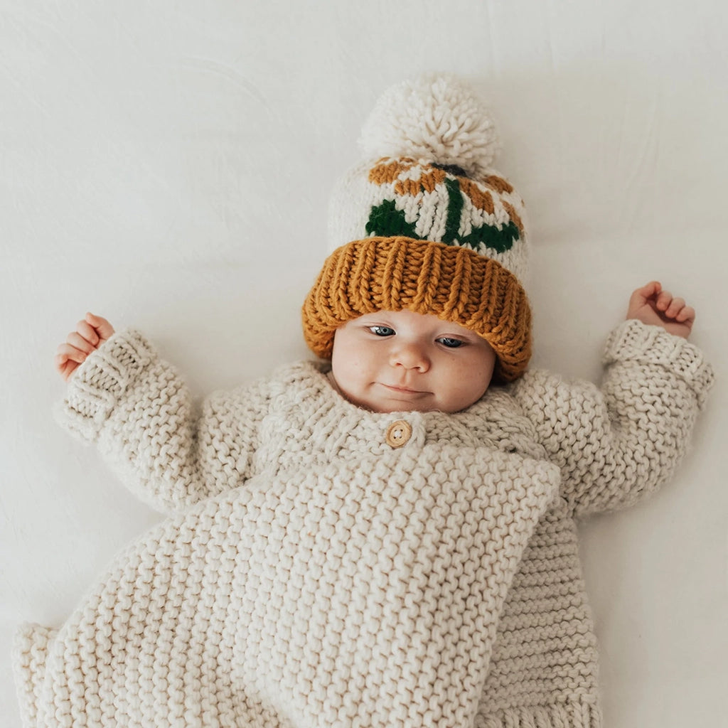 Huggalugs Coneflower Gold Hand Knit Beanie Infant & Toddler Hat modeled on infant.