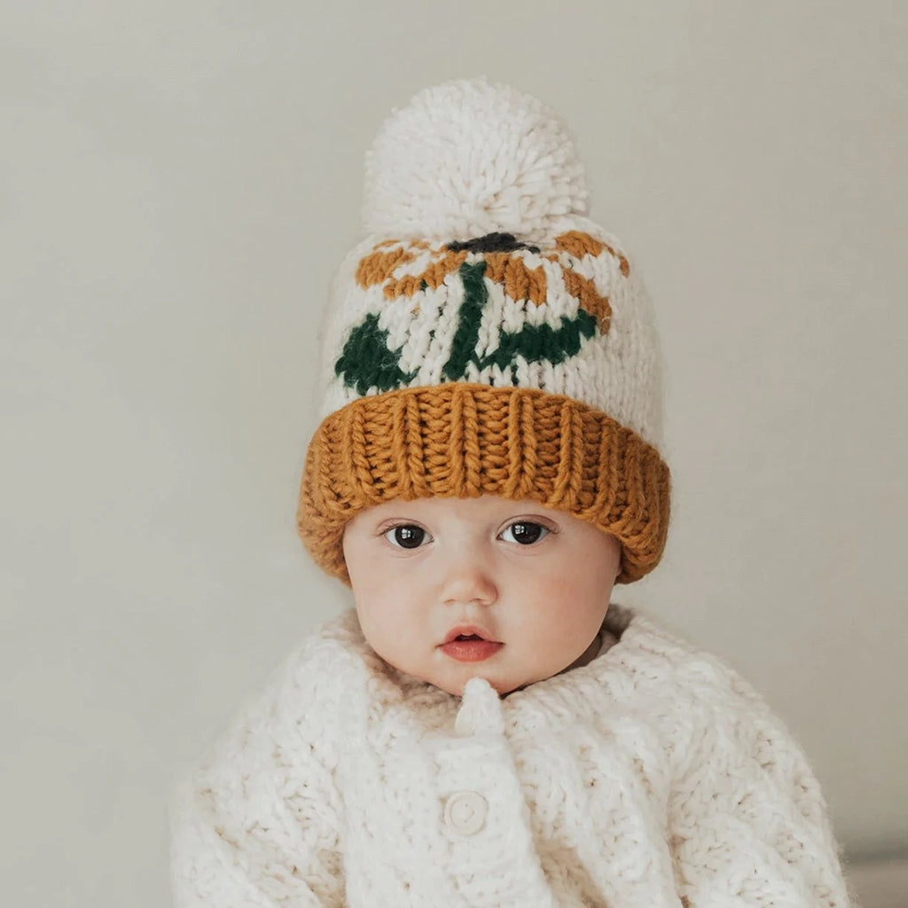 Huggalugs Coneflower Gold Hand Knit Beanie Infant & Toddler Hat modeled on infant.