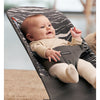 laughing baby laying in baby bouncer seat babybjorn in landscape