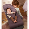 infant with sister in dark purple cotton quilt babybjorn bouncer bliss
