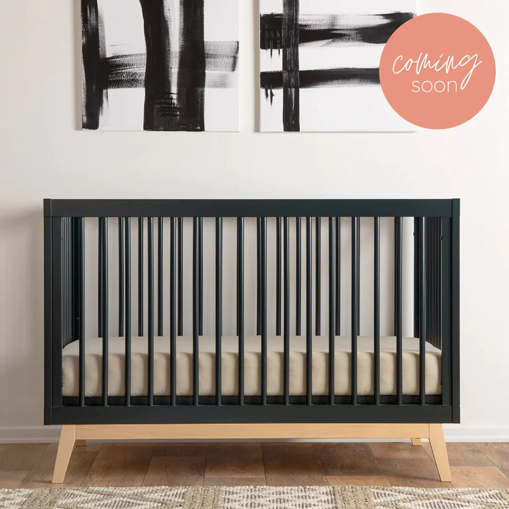 Lifestyle image of Soho Crib in Black in a nursery. 