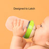 baby drinking from comotomo bottle in green