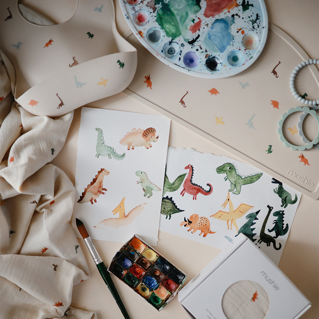 Mushie Silicone Placemats in Dinos Featuring friendly dinosaur illustrations adding excitement to mealtime