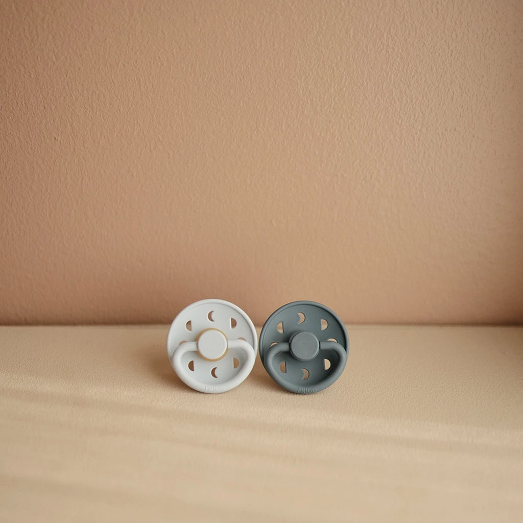 FRIGG Moon Phase Natural Rubber Baby Pacifier. Two color variations pictured together.