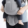 close up of baby supported in grey babybjorn free baby carrier