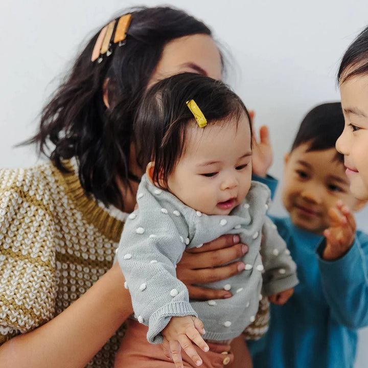 Parent and infant wearing Hello Tartlet hair clips. Petite on infant, large on adult.