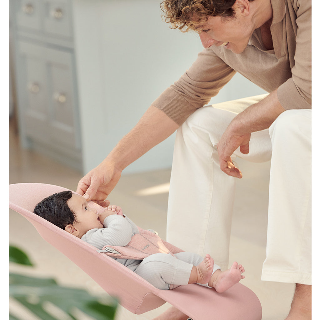 dad smiling at baby in light pink babybjorn bouncer bliss infant bouncer