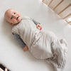 Baby in Crib wearing Kyte Baby Sleep Sack in Oat