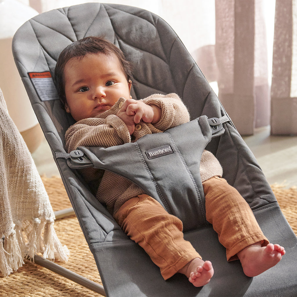 infant in bedroom resting in babybjorn bouncer seat light grey