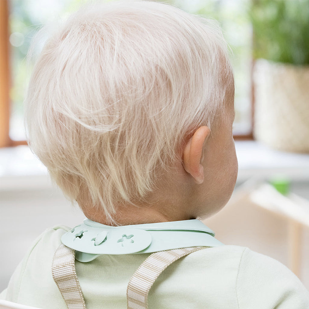 Stokke Munch Bib - Soft Mint, with a deep spill-catching pocket to minimize mealtime mess