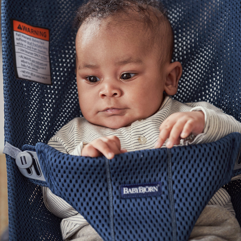 close up of baby in baby bjorn navy blue mesh bouncer bliss