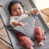 infant lying in Baby Bjorn baby bouncer in grey mesh