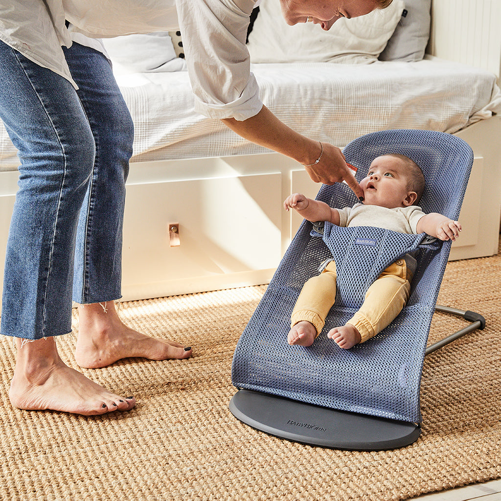 mom playing with infant in slate blue Baby Bjorn bouncer bliss