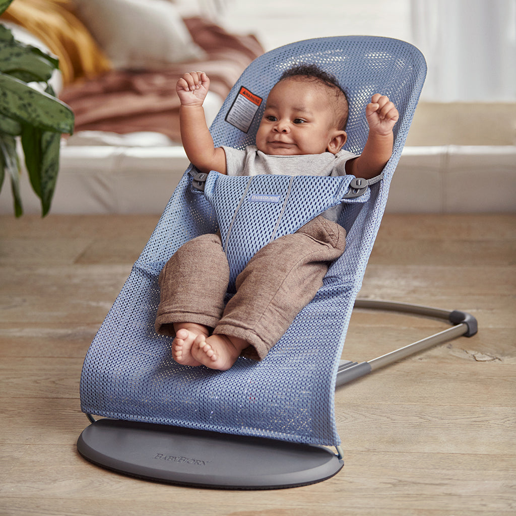 infant raising arms in babybjorn bouncer bliss blue mesh